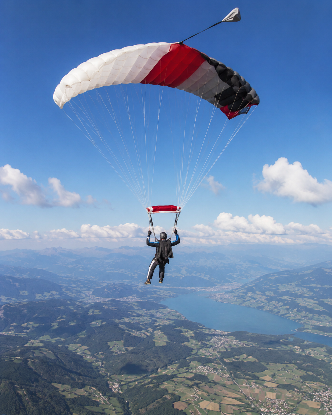 Paracaidista en pleno salto con el paracaídas abierto sobre un cielo despejado